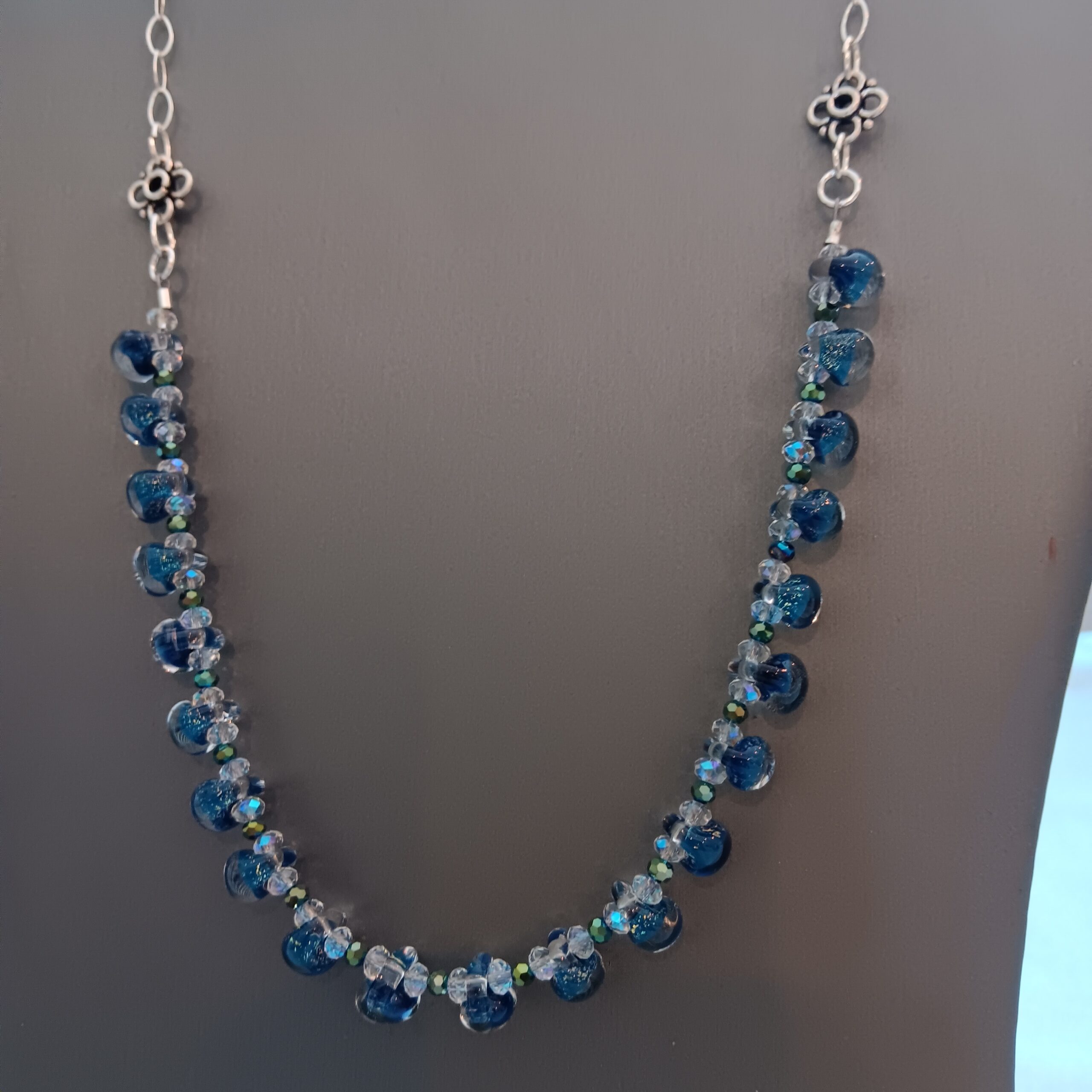 Drops of clear and dark teal beads on necklace